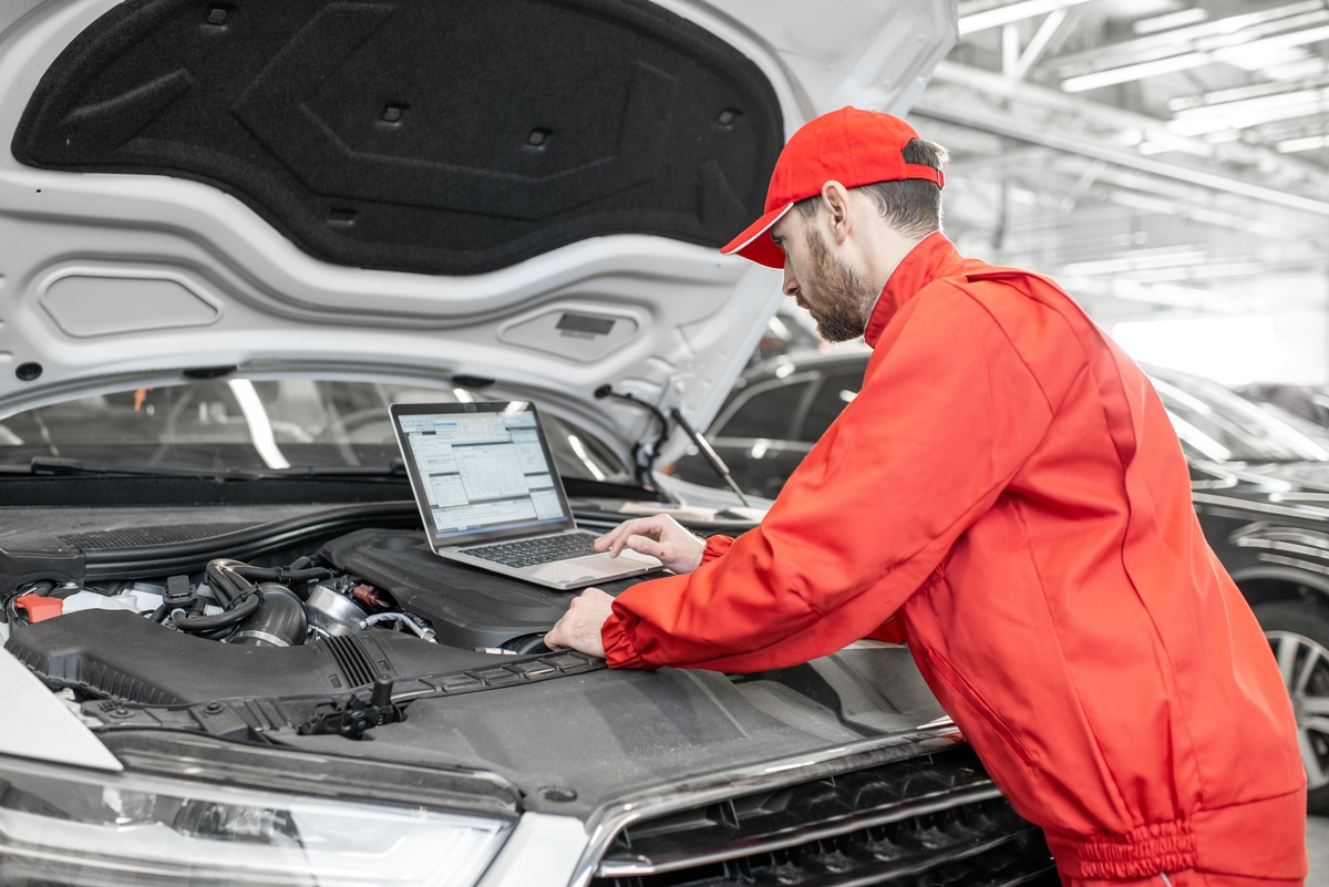 auto mechanics doing diagnostics with laptop