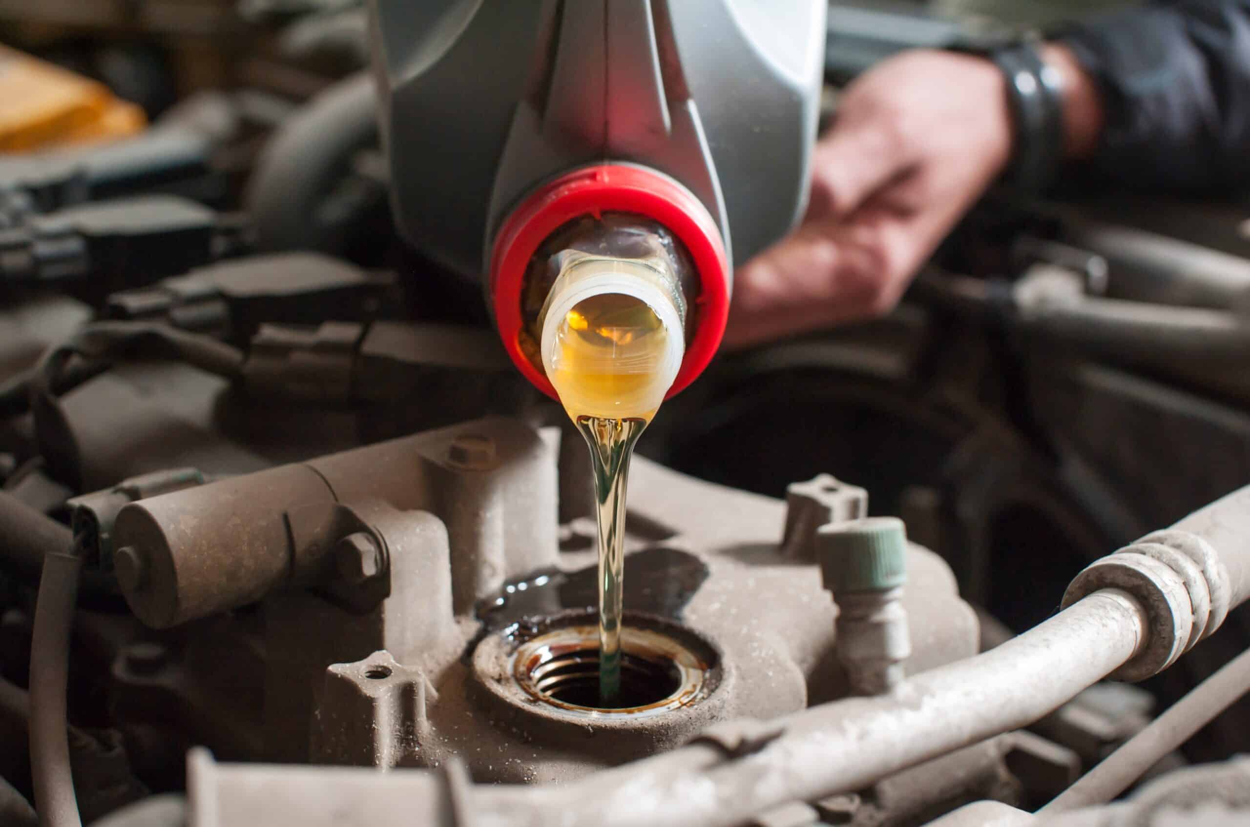 a man pours oil into a car engine close up 2023 11 27 05 09 25 utc