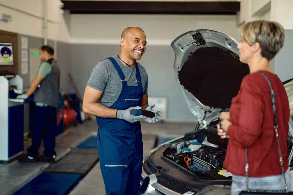 happy african american auto repairman talking to c 2023 11 27 05 07 08 utc(2)