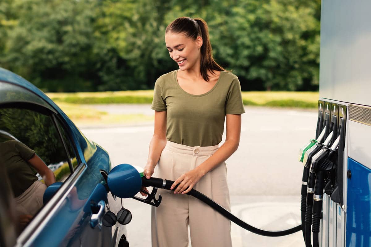 smiling woman refilling auto with fuel at modern p 2023 11 27 05 07 12 utc(1)