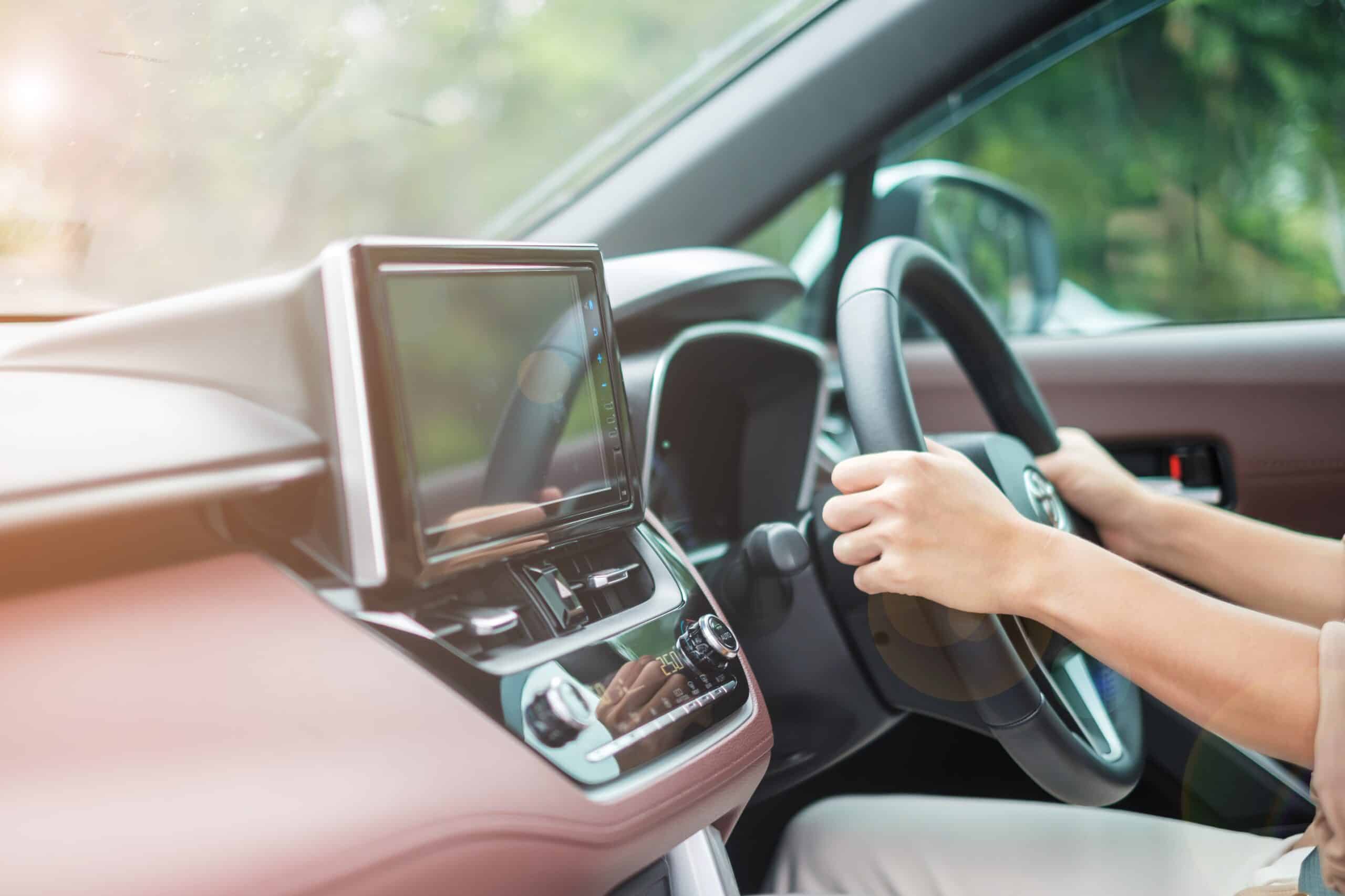 woman driver driving a car on the road, hand controlling steerin